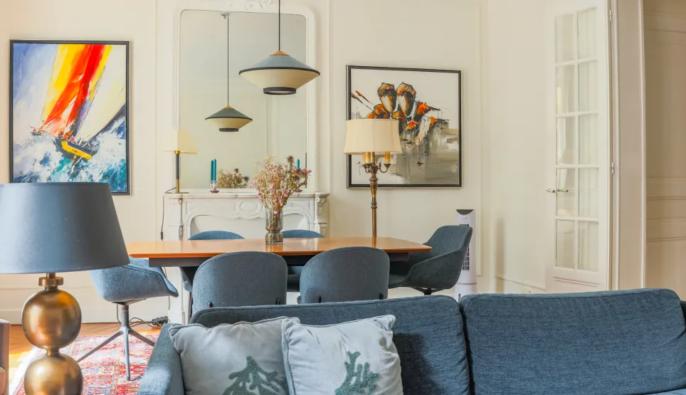 Elegant living-dining room in a luxury apartment. Contemporary design, refined furniture, artworks. Bright and chic ambiance.