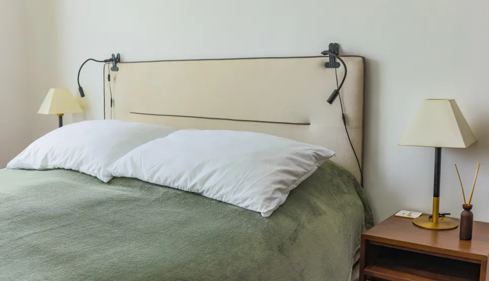 Modern luxury bedroom. Cozy bed, designer headboard, integrated lighting, elegant bedside table. Serene space for optimal rest.