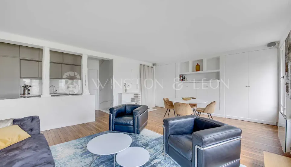 Bright open-plan living and dining room with integrated modern kitchen. Designer furniture, contemporary and refined ambiance for a luxury apartment.