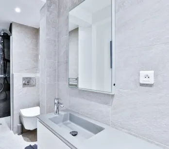 Luxury modern bathroom: walk-in shower, designer sink, wall-hung toilet, elegant tiling. High-end finishes for an exceptional property.