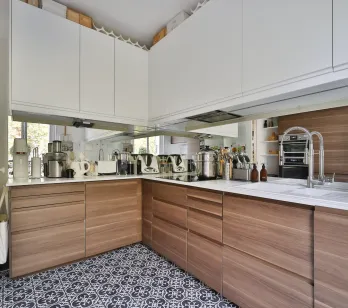 Modern luxury kitchen with wood/white cabinets, designer tiles. Integrated appliances, mirror wall. Functional, elegant space for contemporary living.