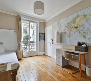 Bright Parisian bedroom/office, hardwood, balcony, world map. Modern design & classic elegance for a luxury interior.