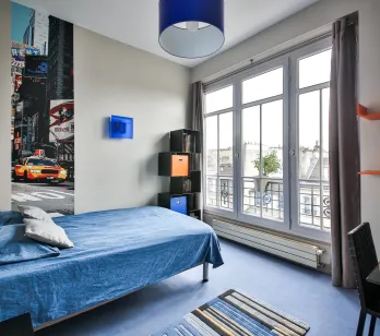 Luxury apartment bedroom: modern, bright, city view. Features a comfortable bed, contemporary design, and urban chic decor with Times Square mural.