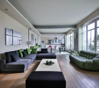 Modern luxury living room with designer sofas, hardwood floors, open kitchen. Spacious, bright apartment for contemporary living.