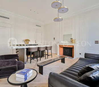 Luxury Parisian living room, contemporary & classic design fusion. Elegant apartment with bar, fireplace, moldings, parquet, and high-end furniture.