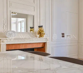 Elegant Haussmannian interior: classic moldings, ornate fireplace, mirror, marble table. Refined Parisian luxury, chic design.