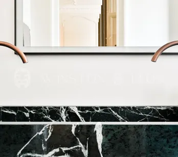 Luxury bathroom: double green marble vanity, designer copper faucets. Modern elegance for a refined interior.
