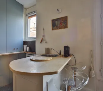 Modern, elegant kitchen with island/bar, breathtaking Parisian rooftop views. Luxury Paris apartment, contemporary design.