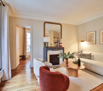Luxury Parisian living room, modern and elegant design with fireplace, hardwood floor, natural light. Ideal for a high-end apartment.
