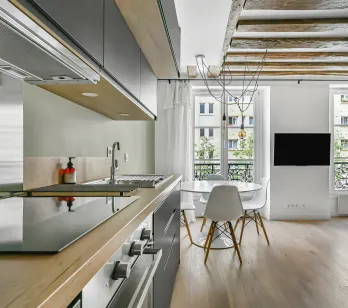 Luxury apartment: modern open kitchen, bright living room, exposed beams, hardwood floors. Parisian elegance.