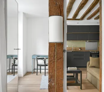 Luxury renovated interior: exposed beams, modern kitchen, elegant design. Old charm meets contemporary comfort.