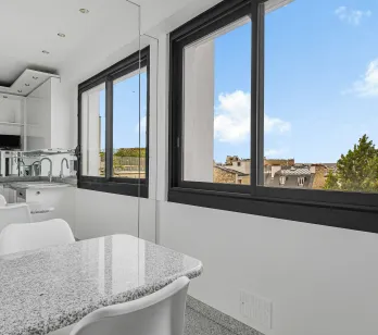 Bright modern kitchen, granite island, urban view. Sleek design for a contemporary luxury apartment.