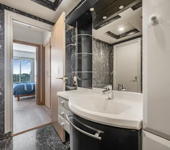 Elegant black marble bathroom, modern design with integrated sink. Access to bright master suite with view. Luxury and comfort.