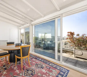 Bright solarium/veranda dining area with direct access to a private rooftop terrace offering open city views. Perfect for a luxury penthouse.
