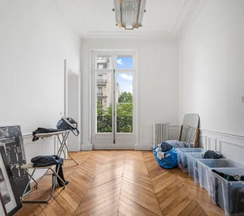 Bright Parisian Haussmann apartment. Herringbone parquet, moldings, balcony window. Luxury potential, green view.