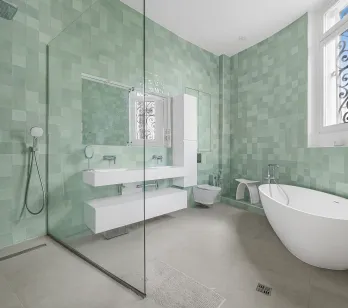 High-end bathroom with sage green zellige tiles, contemporary freestanding bathtub, walk-in shower, and floating double vanity.