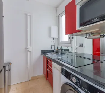Modern, elegant, fully equipped kitchen (washer, microwave), contemporary red and black design. Ideal for luxury apartment.