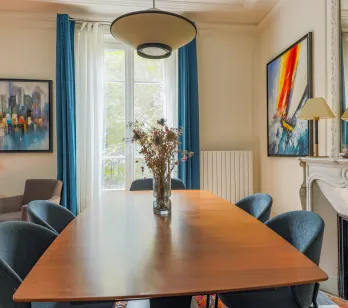 Elegant, bright dining room with modern design and artistic touches. A refined space with fireplace for luxury property.