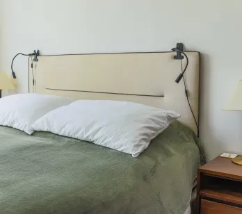 Modern luxury bedroom. Cozy bed, designer headboard, integrated lighting, elegant bedside table. Serene space for optimal rest.