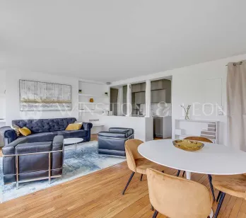 Bright modern living & dining room. Velvet sofa, design armchairs, oval table. Chic contemporary interior for luxury property.