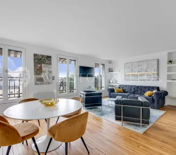 Bright luxury apartment featuring modern living/dining, hardwood floors, large windows with city views. Elegant and contemporary design.