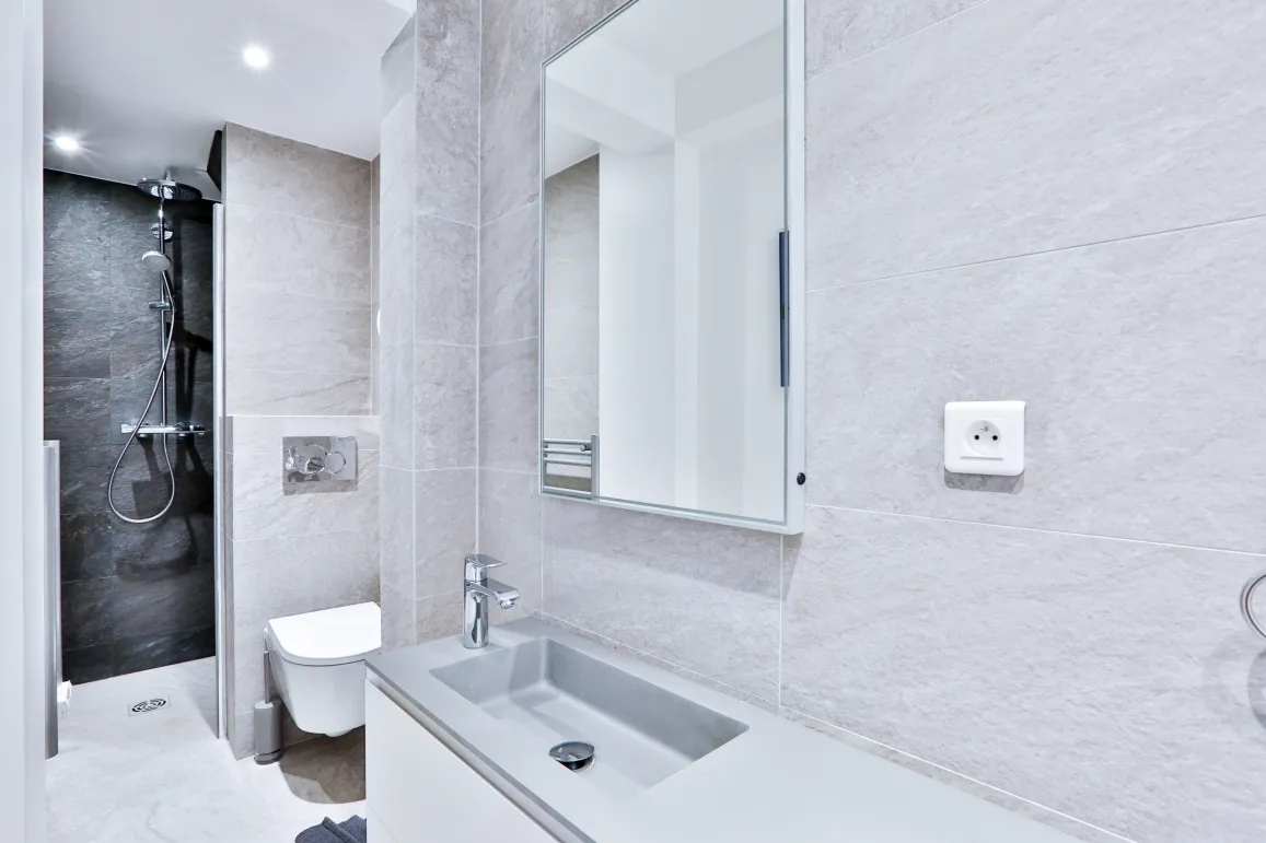 Luxury modern bathroom: walk-in shower, designer sink, wall-hung toilet, elegant tiling. High-end finishes for an exceptional property.