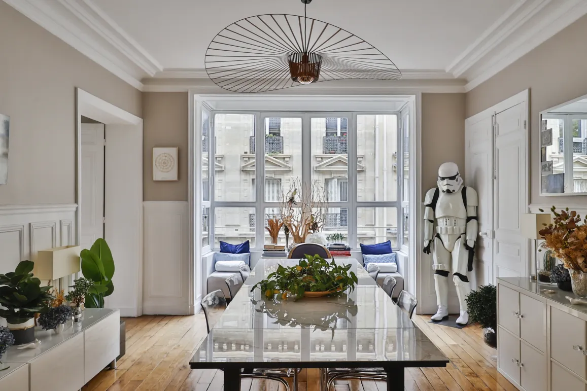 Luxury Parisian apartment: elegant dining room, modern design with a unique Stormtrooper touch. City view, bright interiors.