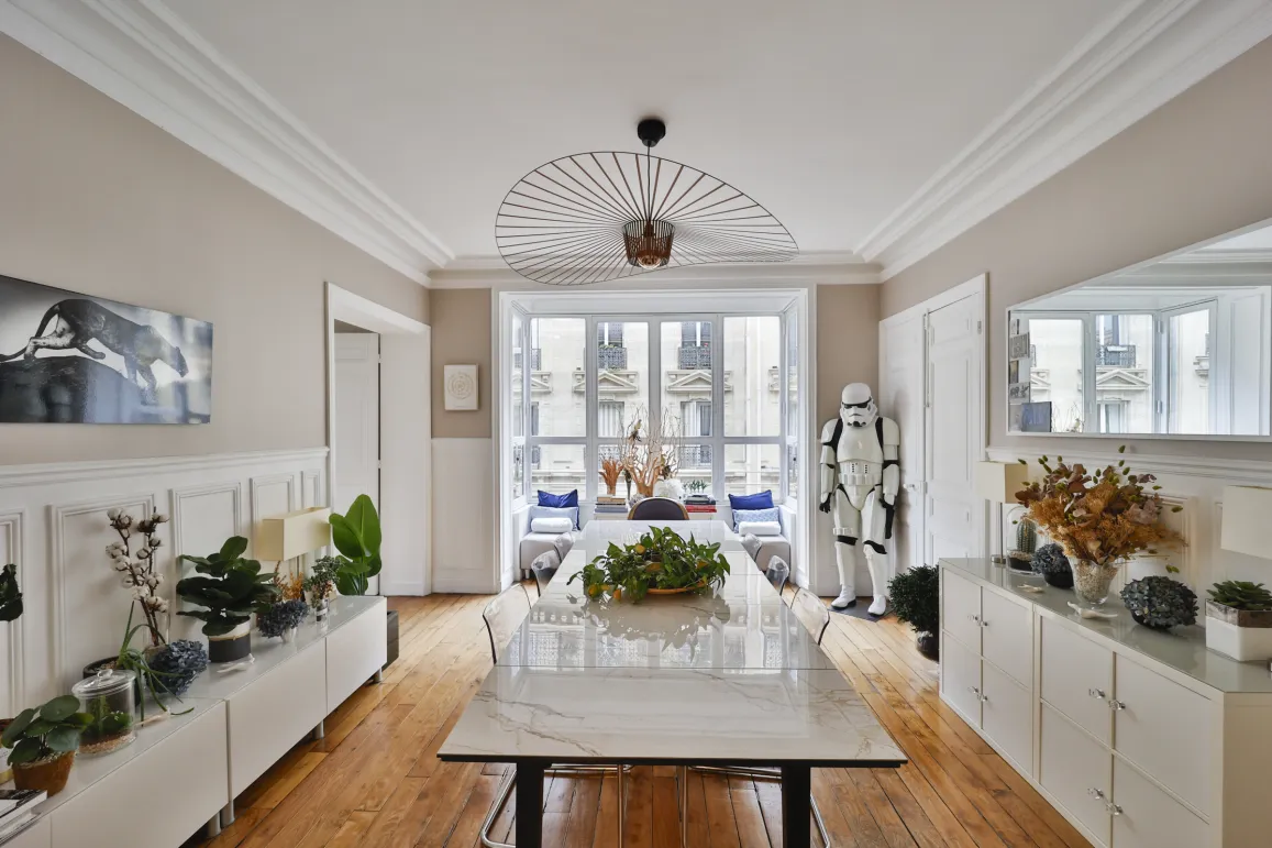 Luxury Parisian dining room, modern eclectic design. Bright, parquet, moldings, and city view. A unique and refined interior.