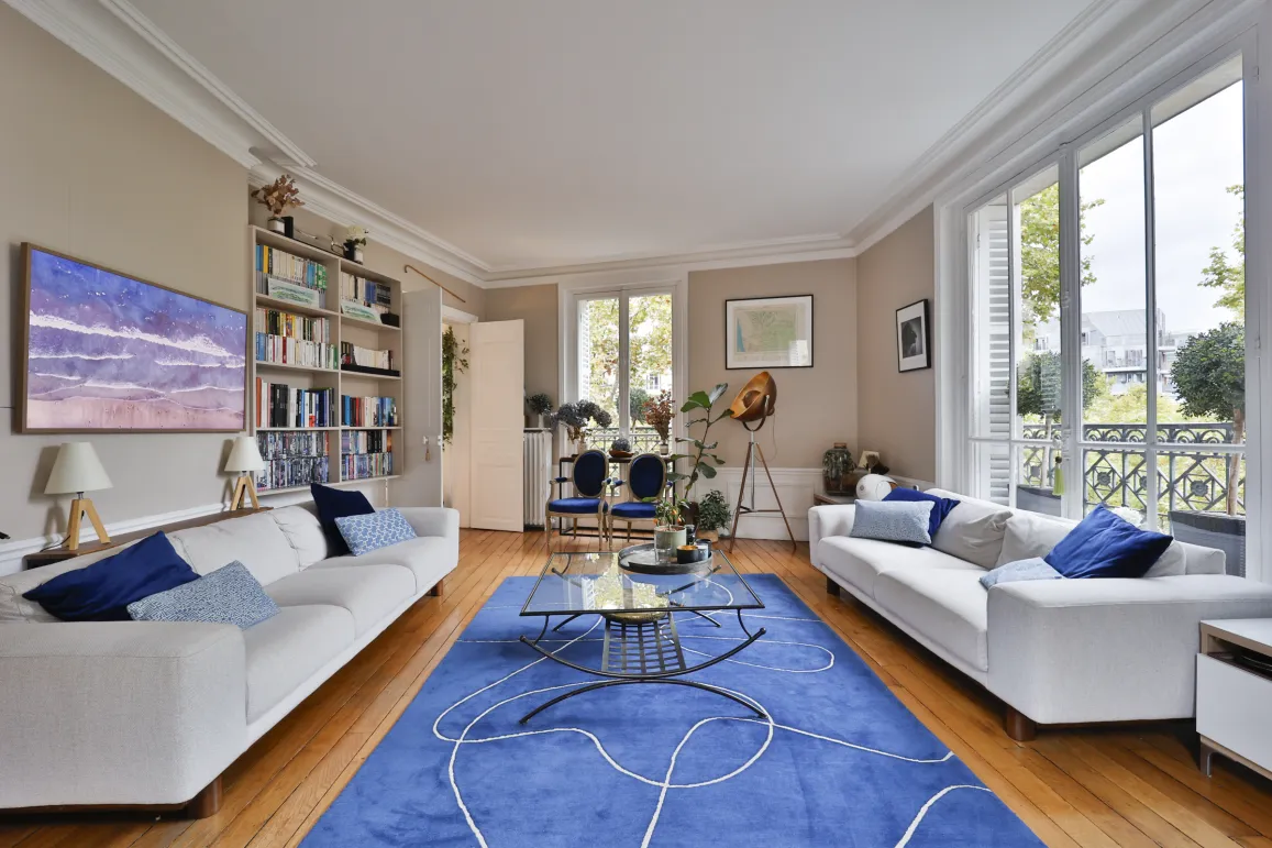 Luxury apartment: spacious, bright living room, contemporary design, hardwood, white sofas, blue rug. Ideal for elegant urban living.