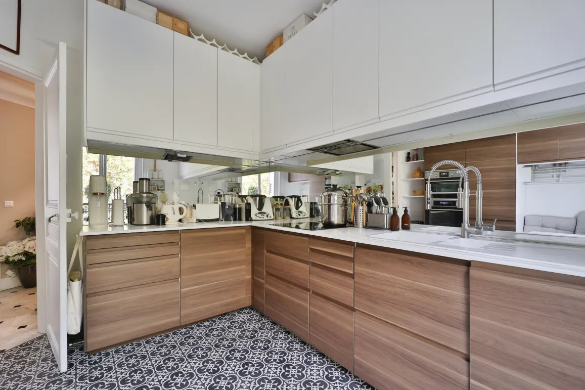 Modern luxury kitchen featuring wood and white cabinetry, sleek countertops, integrated appliances, and designer tiles. Elegant and bright ambiance.