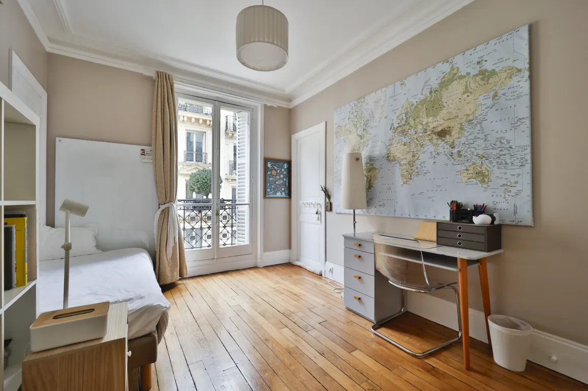 Elegant Parisian bedroom, hardwood floors, balcony, desk. Perfect luxury pied-à-terre in the heart of Paris.