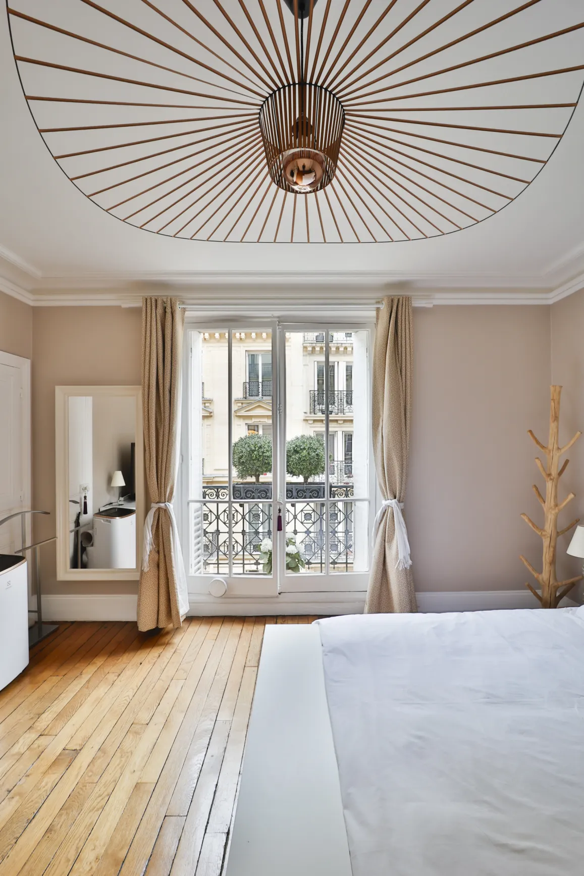 Elegant modern luxury bedroom featuring parquet floor, unique designer lighting, and balcony. Perfect for a high-end Parisian apartment.