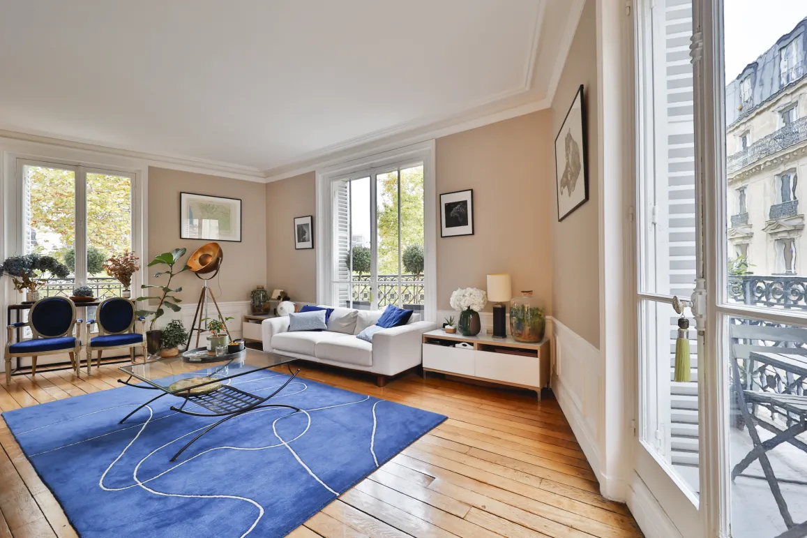 Luxury Parisian living room, bright and elegant. Hardwood floors, large windows, refined design. Ideal for an exceptional apartment.