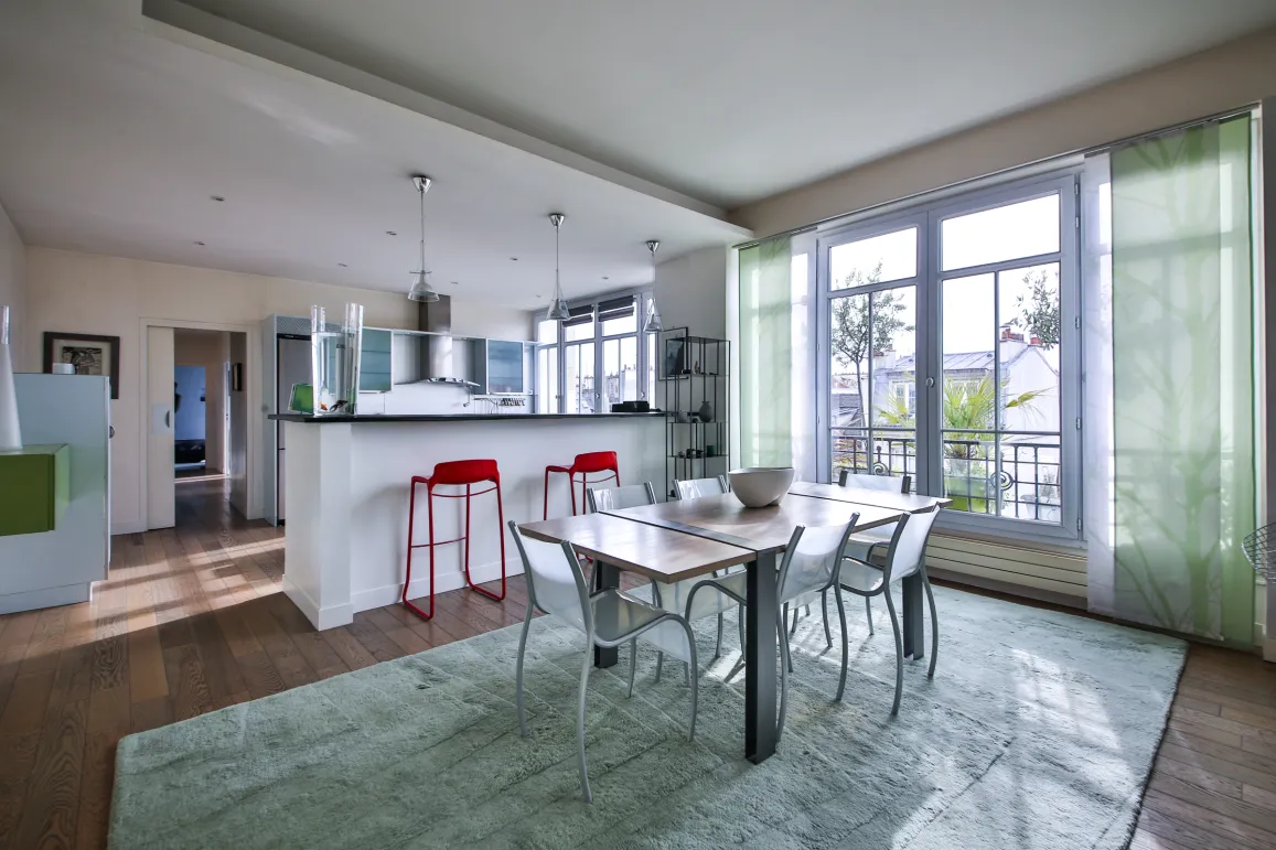 Modern luxury apartment with open kitchen, bright dining area, and scenic views. Contemporary design, hardwood floors, and large windows.