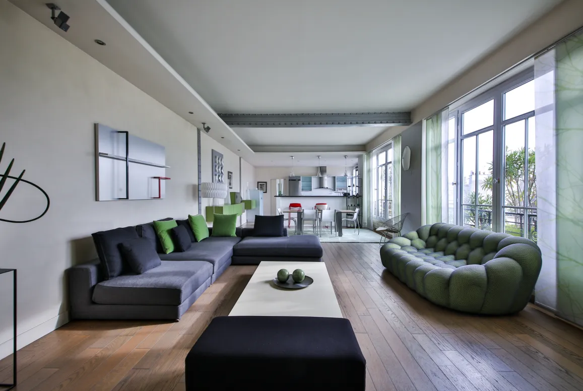 Modern luxury living room with designer sofas, hardwood floors, open kitchen. Spacious, bright apartment for contemporary living.