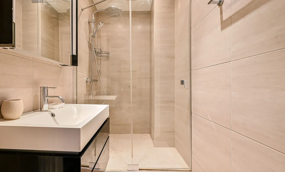 Contemporary bathroom: walk-in shower, designer sink, light tiles. Zen and luxury ambiance for exceptional property.