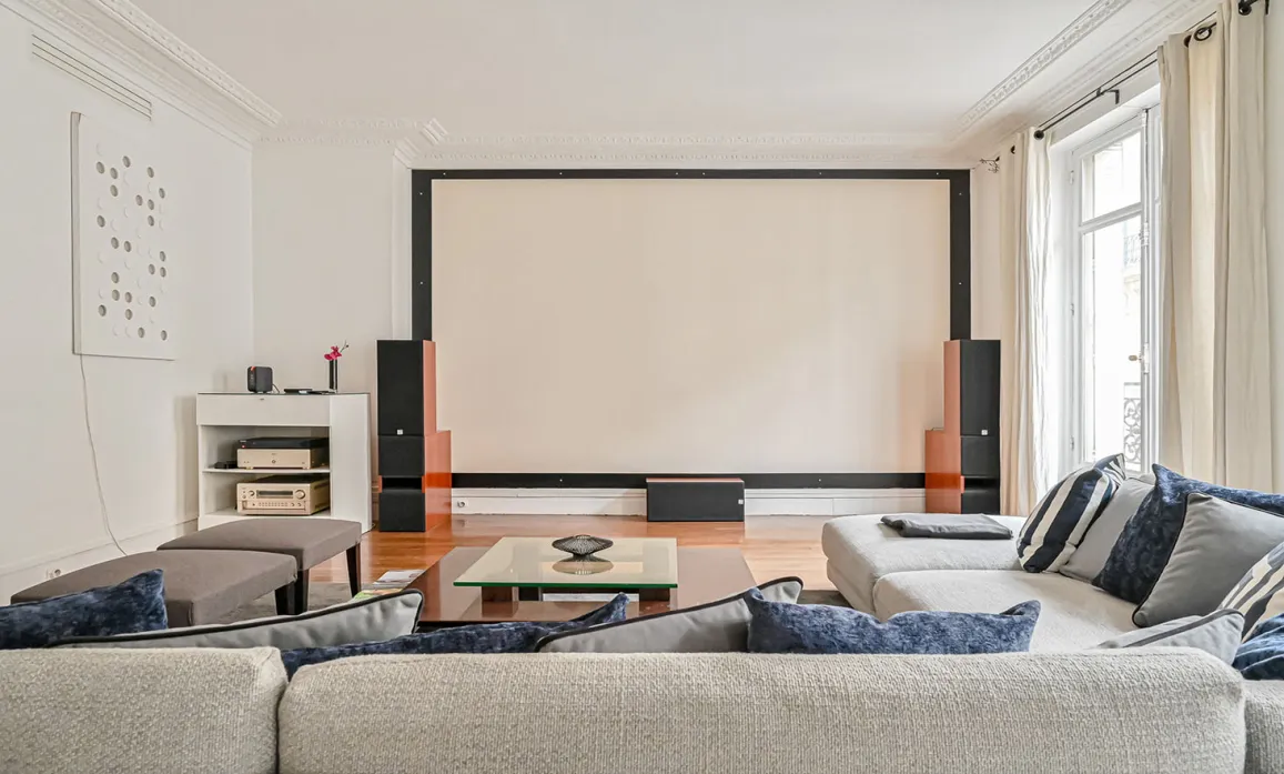 Luxury living room featuring integrated home cinema, large projection screen, and comfortable sofas. Ideal for high-end entertainment and movie nights.