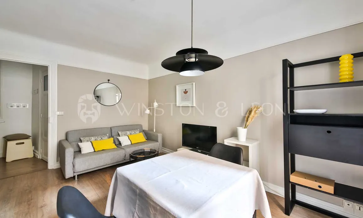 Modern, bright living space: living room with grey sofa, yellow cushions, minimalist dining area. Ideal for a luxury apartment.