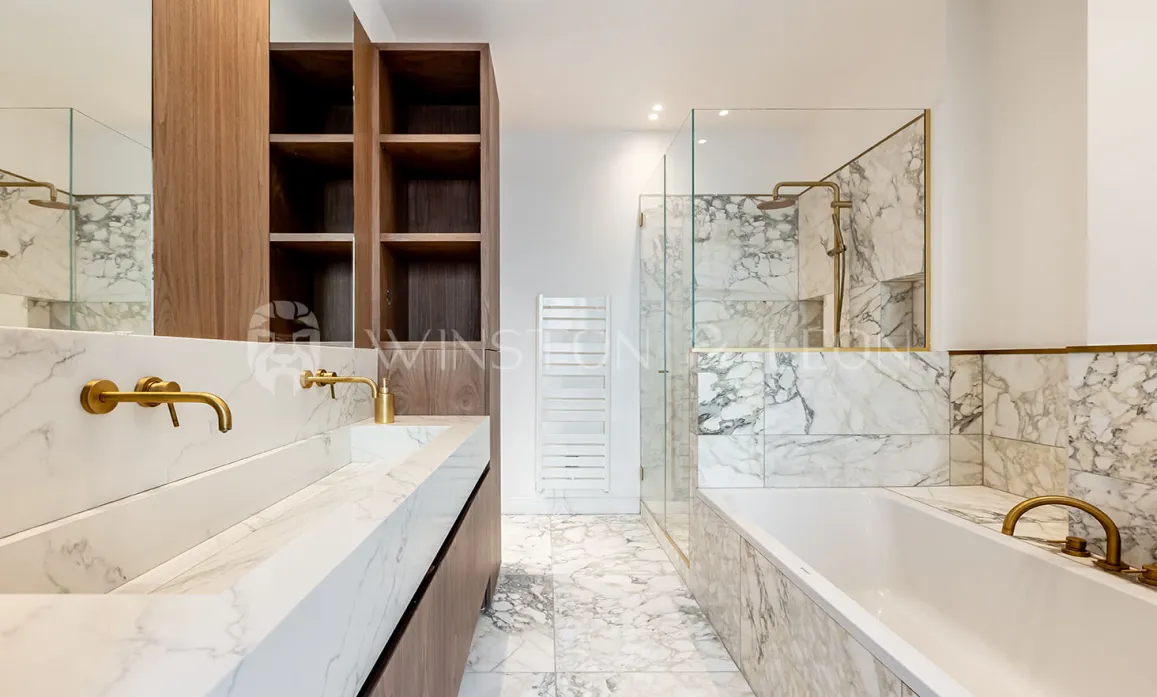 Modern luxury bathroom: white marble, double vanity, gold fixtures, walk-in shower and bathtub. Elegant design.