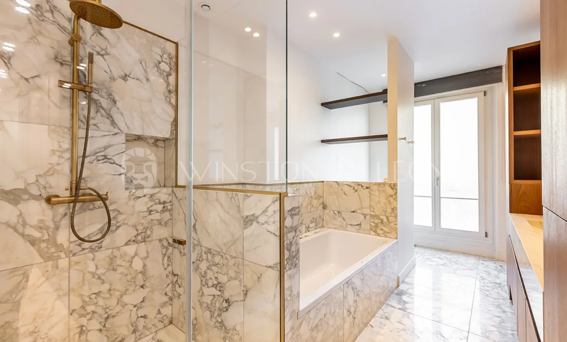 Luxury marble bathroom, walk-in shower, bathtub, gold fixtures. Modern, elegant design for prestigious real estate.