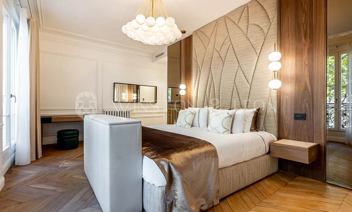 Luxurious bedroom with contemporary and classic design. Textured headboard, elegant parquet, sophisticated lighting. Ideal for high-end real estate.