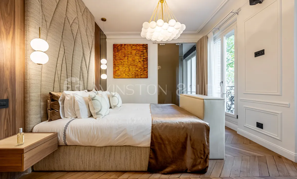 Luxury Parisian bedroom with modern design, textured headboard, parquet, elegant lighting. Comfort and style for an exceptional apartment.