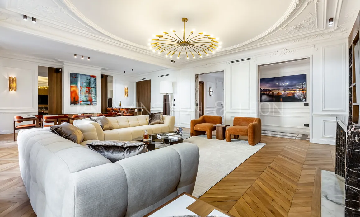 Stunning Parisian luxury apartment living room. Modernized Haussmannian style, designer furniture, parquet, moldings, contemporary chandelier.