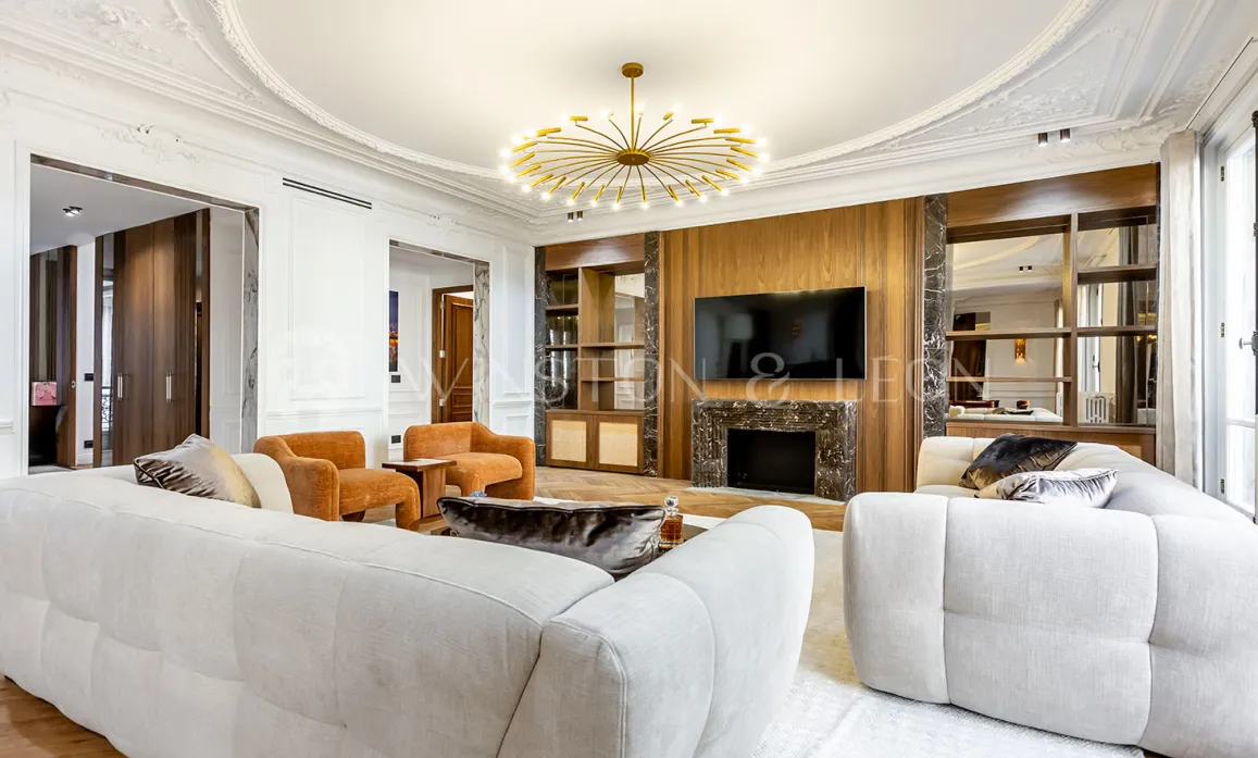 Luxury contemporary living room with marble fireplace, integrated TV, white sofas & gold chandelier. Elegant interior design for prestige apartment.