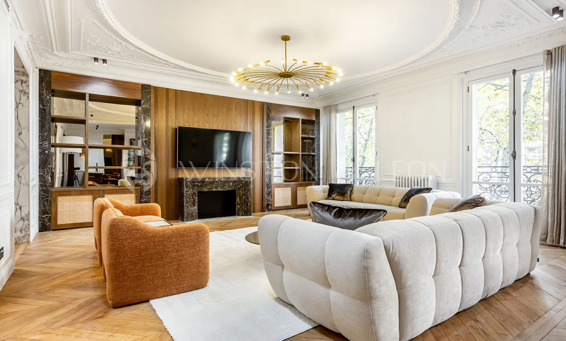 Stunning luxury living room: modern design, marble fireplace, parquet, moldings, designer sofas. Bright and refined ambiance for Parisian apartment.