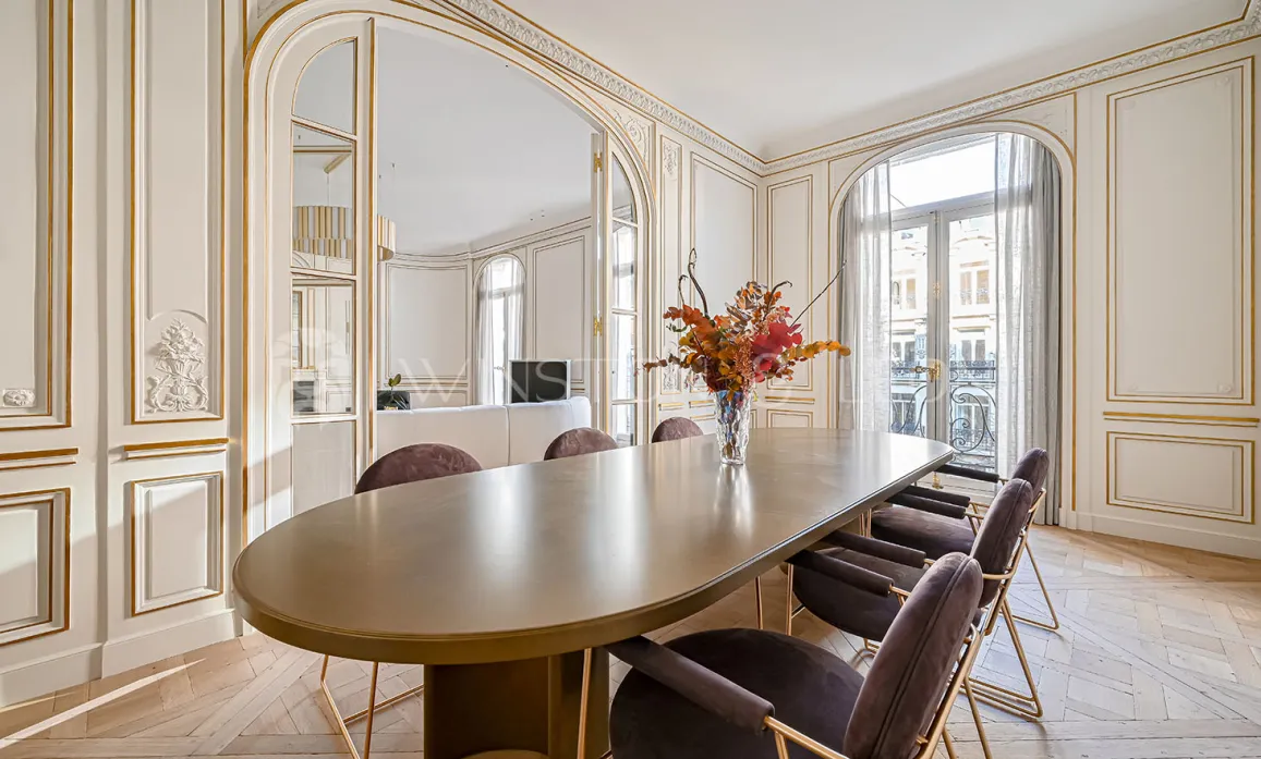 Luxury Parisian dining room: gold mouldings, parquet flooring, contemporary design. Elegance and prestige for an exceptional apartment.
