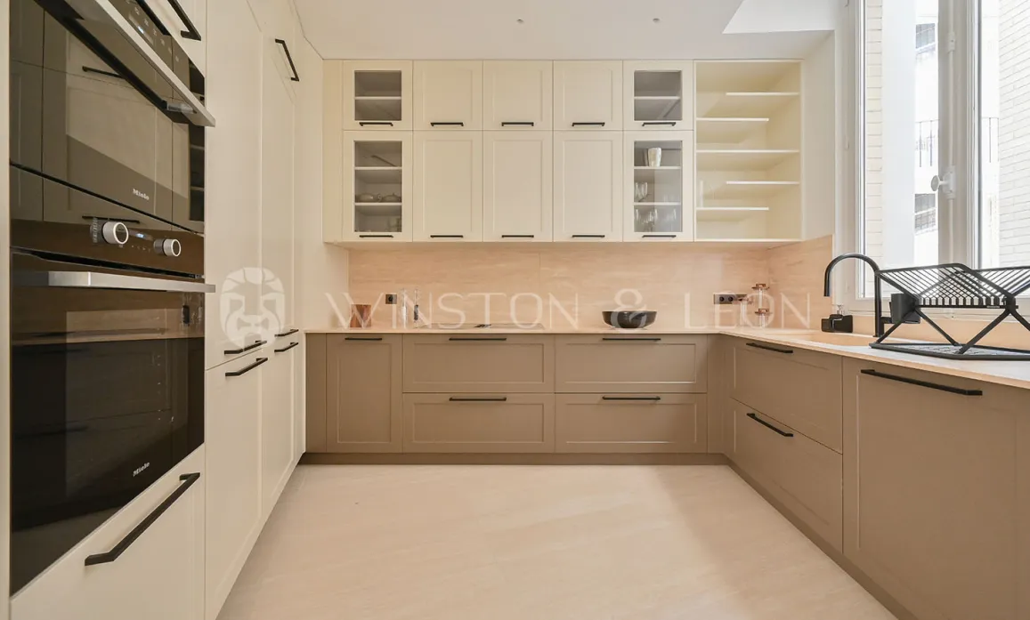 Modern luxury kitchen: two-tone (cream/taupe) design, integrated Miele appliances. Elegant & functional high-end space.