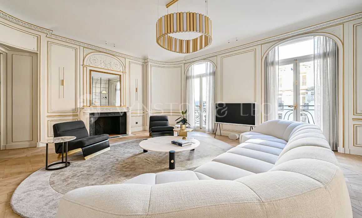 Luxury Parisian living room. Modern & classic Haussmannian design, gold moldings, contemporary sofa. Elegant and refined.