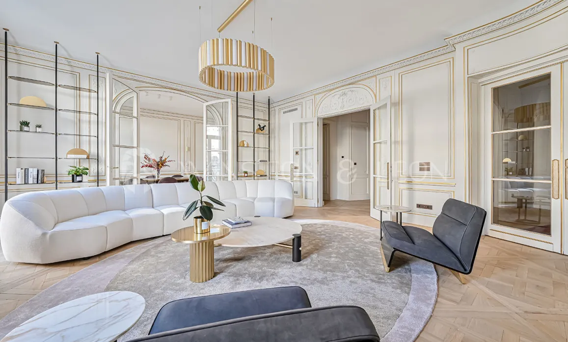 Luxury contemporary living room, gold mouldings, designer sofa, herringbone parquet. Bright Parisian elegance and refinement.