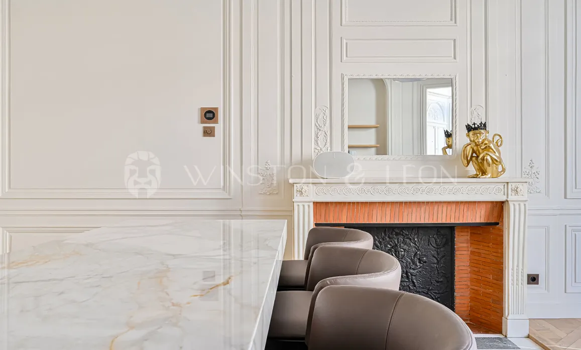 Luxury Parisian interior: marble table, classic fireplace, moldings. Timeless elegance for a high-end property.